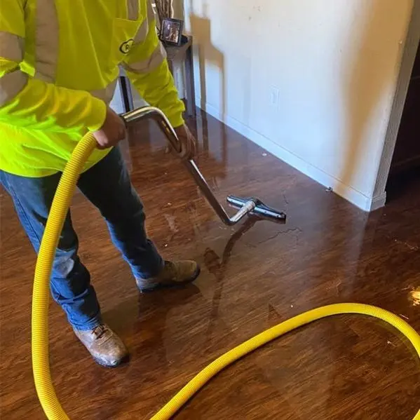 Technician vacuuming standing water off a Maple Grove, MN hardwood floor